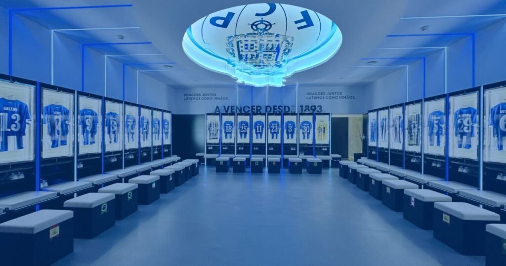 Balneário do FC Porto com camisolas alinhadas e símbolo do clube no teto, representando mística e união.
